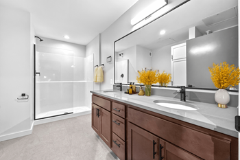 A bathroom with brown cabinets and a white counter top.